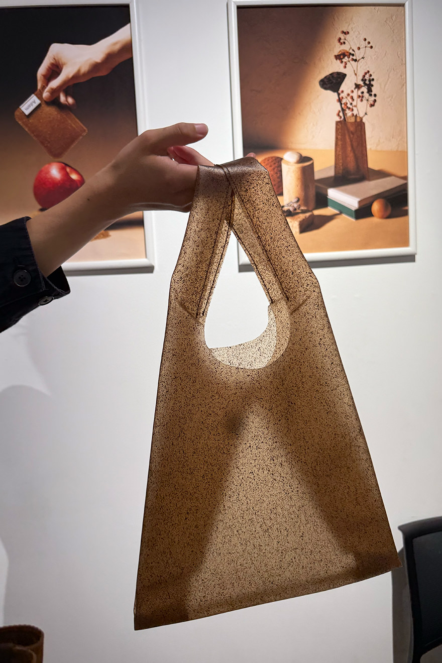 りんごの加工品の製造過程で発生する搾りかす（皮や芯、ヘタ、種など）を活用してつくられたシート材「Adam」。搾りかすの糖分や成分が熱と反応することで生まれる独特の色味に惹かれます